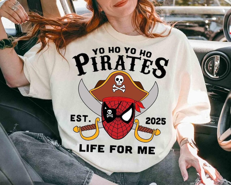 a woman sitting in a car wearing a shirt with a pirate on it