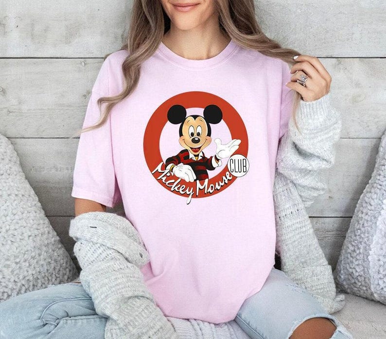 a woman wearing a pink mickey mouse shirt