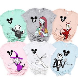 May include: Assorted-color t-shirts featuring characters from The Nightmare Before Christmas. Each shirt has a character holding a black Mickey Mouse balloon with a number. Names are printed below the characters.
