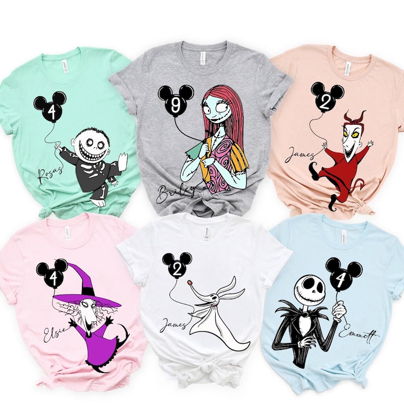 May include: Assorted-color t-shirts featuring characters from The Nightmare Before Christmas. Each shirt has a character holding a black Mickey Mouse balloon with a number. Names are printed below the characters.