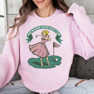 ピンクのゴルフ妻 - Abandoned Wives Club レディース ゴルファー ユニセックス ウェア、ゴルフトーナメント、ゴルフシャツ、ゴルフアパレル、女の子ゴルファーへのギフト