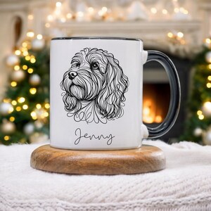 May include: White ceramic mug with a black handle. The mug features a black and white line drawing of a dog's head with the name "Jenny" written below the image.