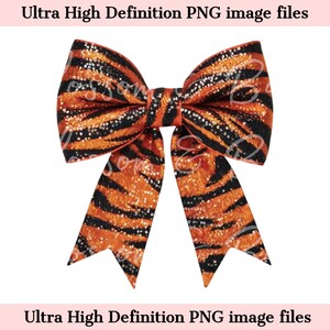 May include: A large orange and black bow with a tiger stripe pattern. The bow is made of fabric with a sparkly finish.