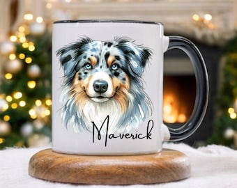 May include: White ceramic mug with a black handle and rim, featuring a detailed illustration of a dog with blue eyes and a multi-colored coat. The name "Maverick" is written in cursive below the dog's image. The mug sits on a wooden coaster.