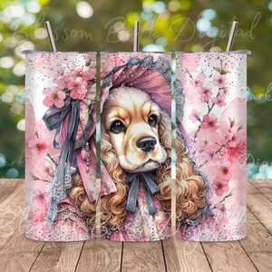 May include: A pink and white tumbler with a watercolor illustration of a cocker spaniel wearing a pink bonnet and surrounded by pink cherry blossoms.