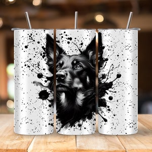 Puede incluir: Un vaso de acero inoxidable blanco con un diseño gráfico en blanco y negro de la cabeza de un perro pastor alemán y salpicaduras de pintura negra.