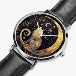 Peut inclure: Une montre-bracelet argentée avec un bracelet en cuir noir. Le cadran de la montre présente une illustration stylisée d'un chat assis sur un croissant de lune sur fond de nuit étoilée.