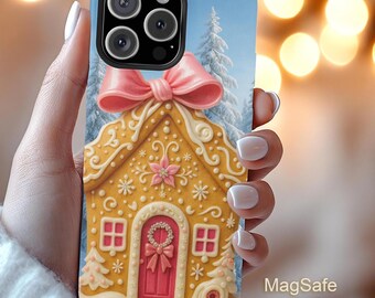 May include: A phone case featuring a gingerbread house design with a pink bow, red door, and snow-covered roof. The case has a blue border and a winter scene background with text that reads "MagSafe Magnetic Cases."