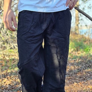 May include: Black cotton pants with a unique patchwork design. The pants have a loose fit and are made of a soft, comfortable fabric.