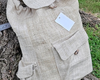 May include: A beige hemp backpack with a drawstring closure and a large front pocket. The backpack has a small brown tag with the text "Himalayan Collection 100% Hemp Made in Nepal".