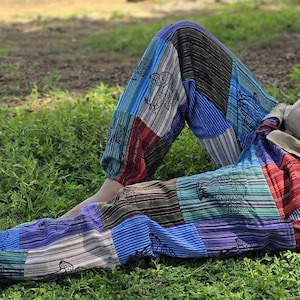 Puede incluir: Pantalones de patchwork con una variedad de colores y patrones, incluyendo azul, rojo, verde y marrón. Los pantalones tienen un corte holgado y están hechos de una tela suave y cómoda.
