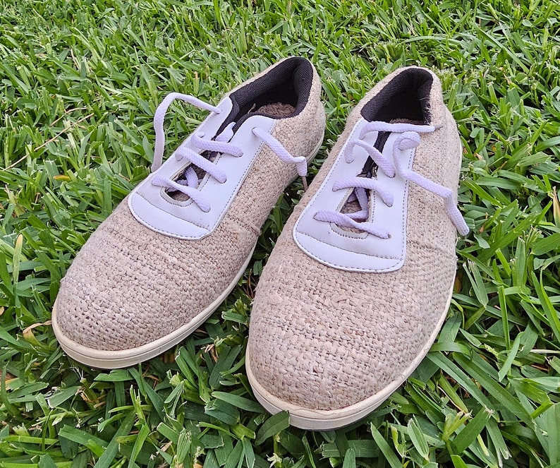 Pode incluir: Dois pares de sapatos de lona bege com cadar&ccedil;os brancos. Os sapatos t&ecirc;m uma parte superior de tecido texturizado e uma sola de borracha branca.