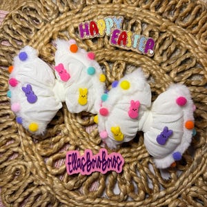 May include: A set of three ceramic mugs with a speckled, cream-colored glaze. Each mug features a different hand-painted floral design in shades of blue, green, and yellow. The mugs have a simple, rounded shape and a comfortable handle.