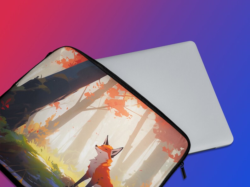Peut inclure: Une housse d'ordinateur portable avec une illustration color&eacute;e d'un renard dans un d&eacute;cor de for&ecirc;t. La housse est noire avec une fermeture &eacute;clair.
