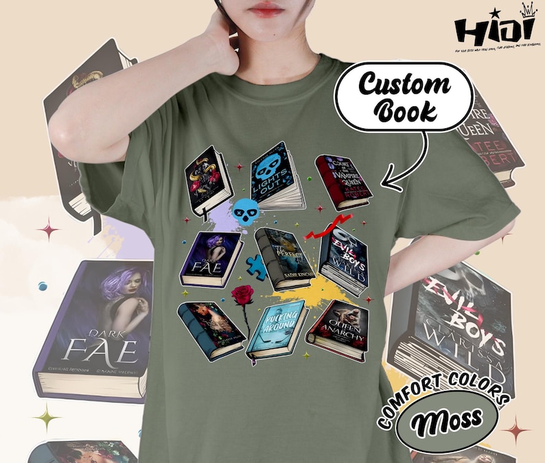 May include: Moss green t-shirt featuring a graphic of various open books with fantasy-themed covers. The words "Custom Book" are above the graphic. The shirt also has the words "COMFORT COLORS" and "Moss" printed on it.