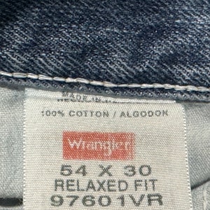 May include: A white tag with black text that reads "Made in", "100% Cotton / Algodon", "Wrangler", "54 X 30", "Relaxed Fit", and "97601VR".