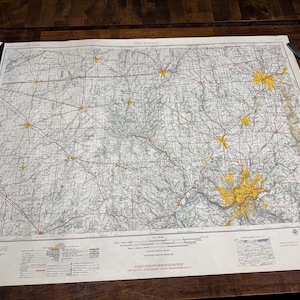 May include: A vintage map of Cincinnati, Ohio, printed on paper with a yellowed tint. The map shows roads, rivers, and towns in the area. The map is titled "Cincinnati" in the upper left corner. The map is surrounded by a white border.
