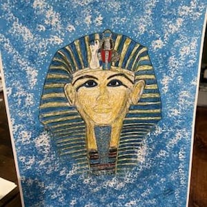 May include: A colorful drawing of the bust of Tutankhamun, the ancient Egyptian pharaoh. The artwork features a blue background with white accents, and the pharaoh's face is rendered in shades of yellow and gold, with a blue and gold headdress.
