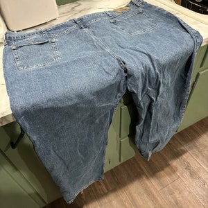 May include: A pair of blue denim jeans with a back pocket and a faded look.