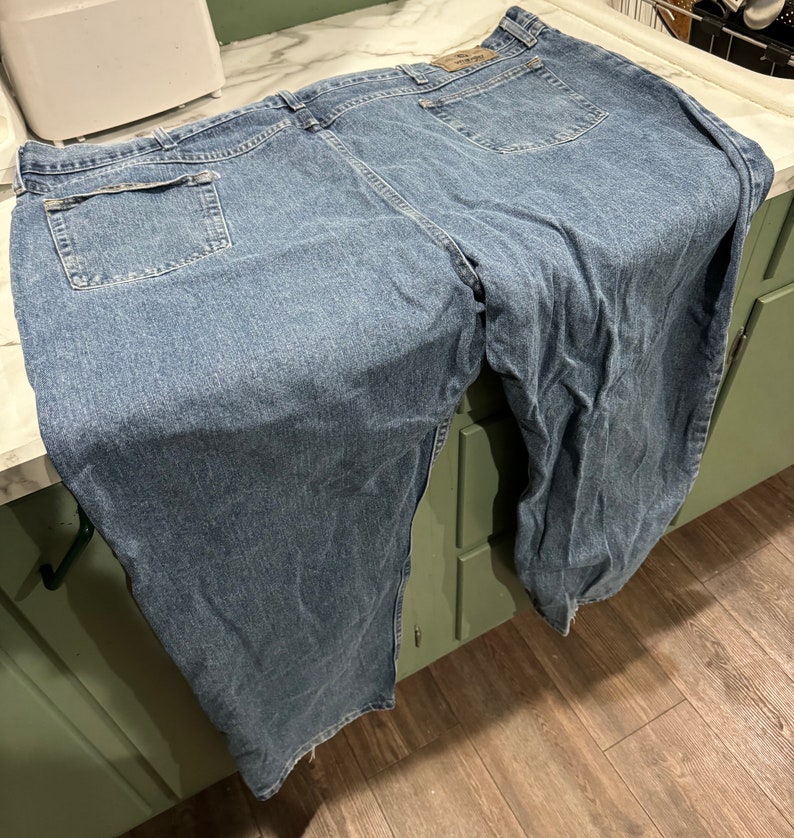 May include: A pair of blue denim jeans with a back pocket and a faded look.