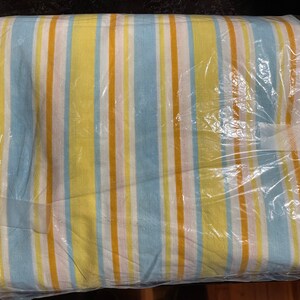 May include: A striped fabric bedding set in a plastic bag. The fabric is yellow, blue, and white.