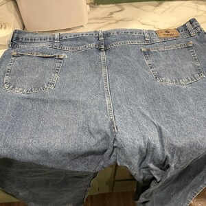 May include: A pair of blue denim jeans with a Wrangler logo on the back pocket.