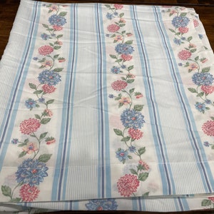May include: White fabric with blue and white stripes and a floral pattern of pink, blue, and green flowers.