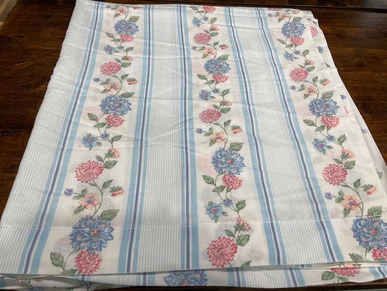 May include: White fabric with blue and white stripes and a floral pattern of pink, blue, and green flowers.