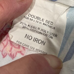 May include: White fabric label with the text "DOUBLE BED FOR 54 x 76 in. MATTRESS 70% KODEL POLYESTER 30% COTTON/CO ON NO IRON FOR CARE SEE REVERSE"