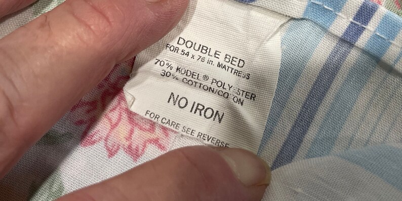May include: White fabric label with the text "DOUBLE BED FOR 54 x 76 in. MATTRESS 70% KODEL POLYESTER 30% COTTON/CO ON NO IRON FOR CARE SEE REVERSE"