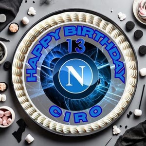 Può includere: Una torta di compleanno rotonda con glassa bianca e le parole "HAPPY BIRTHDAY CIRO 13" in blu. La torta presenta un logo blu e bianco con la lettera "N". Varie caramelle e decorazioni circondano la torta.