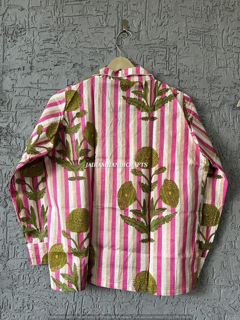 Puede incluir: Camisa a rayas verticales rosas, blancas y beige, adornada con un estampado floral verde oliva. La camisa tiene cuello abotonado. El texto "JAIRAMHANDICRAFTS" est&aacute; impreso en la prenda.