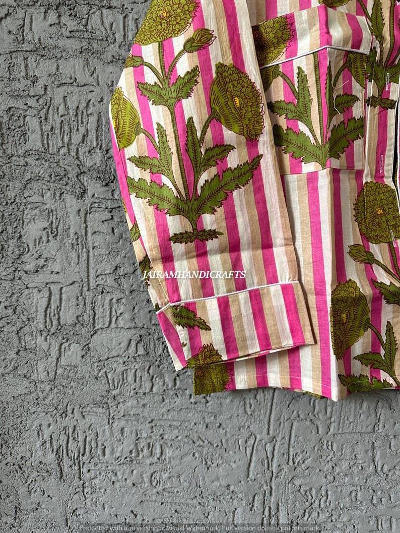 Puede incluir: Top de pijama a rayas rosas y beige con un estampado floral en verde y rosa. La parte superior tiene un bolsillo y ribetes blancos. El texto "Jairamhandicrafts" es visible.