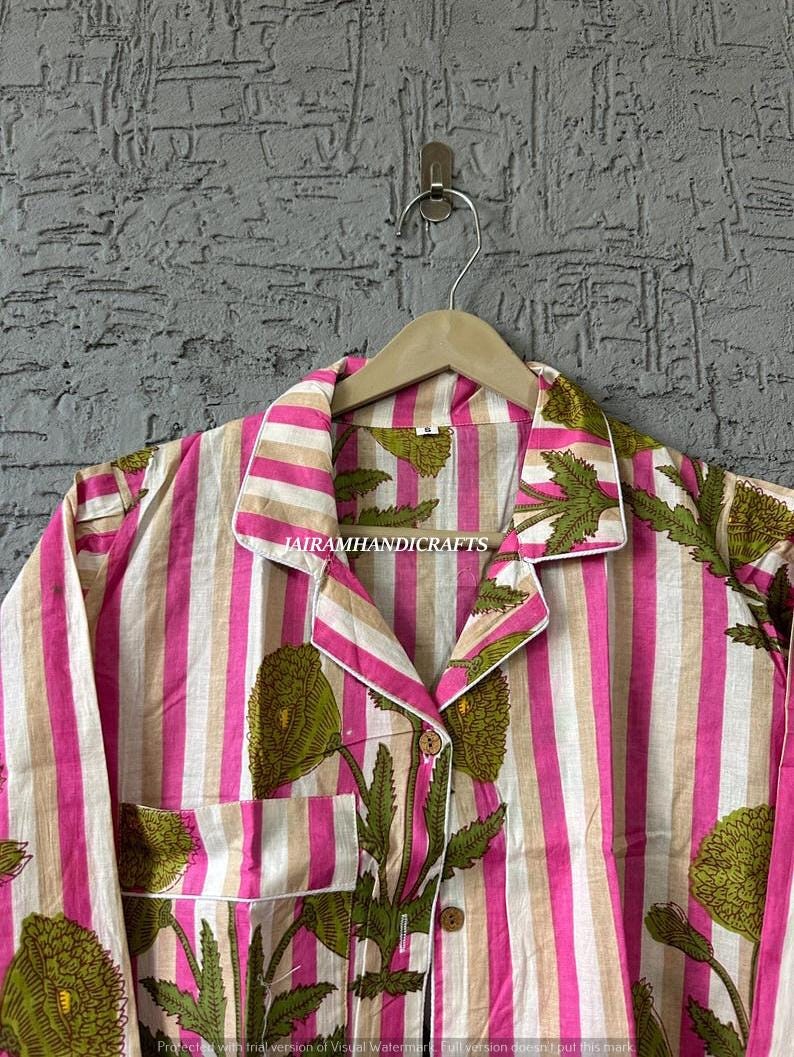Puede incluir: Un conjunto de pijama a rayas en rosa, blanco y beige, con un dise&ntilde;o floral verde. El conjunto incluye una camisa con cuello con botones y un bolsillo en el pecho. El texto "JAIRAMHANDICRAFTS" es visible en la camisa.