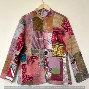May include: A patchwork jacket in shades of pink, burgundy, tan, and green, with a mandarin collar and button closure. The jacket features a variety of fabric patterns and textures, including floral and geometric designs. The text "JAIRAMHANDICRAFTS" is visible.