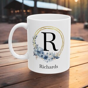 Taza personalizada con monograma inicial y nombre, taza de cerámica personalizada con diseño floral que presenta la letra inicial monogramada en un marco floral