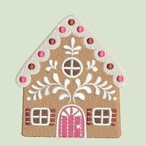 Puede incluir: Una casa de jengibre con glaseado blanco y puntos de caramelo rosa y marrón. La casa tiene una puerta blanca con un centro rosa y ventanas blancas.