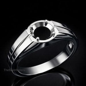May include: A polished silver ring with a circular setting designed to hold a gemstone. The ring has a modern design with a smooth, reflective surface and a black background. TheSilverSellers is printed on the ring.
