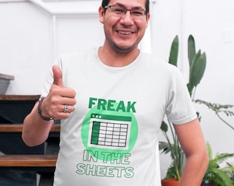 Könnte beinhalten: Weißes T-Shirt mit dem Text "FREAK IN THE SHEETS" in Grün und Weiß. Die Grafik zeigt ein Tabellenkalkulationssymbol in einem grünen Kreis. Die Person trägt eine Brille und zeigt den Daumen nach oben.