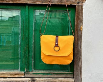 Yellow canvas shoulder bag with leather details, Bag with lid and magnetic closure. Bag with adjustable handle, Interior pocket.