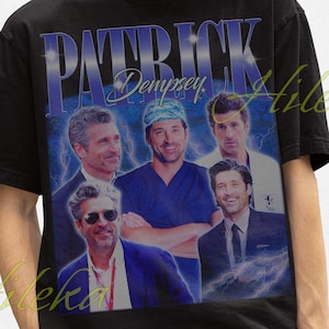 May include: Black t-shirt featuring a graphic of Patrick Dempsey with the text "PATRICK Dempsey" in a blue and white design. The shirt has a vintage style and is worn by a person.