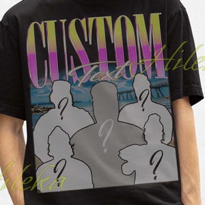 Puede incluir: Camiseta negra con el texto "CUSTOM" colorido y un diseño de siluetas con signos de interrogación. La camiseta se lleva con un sombrero de pescador negro.