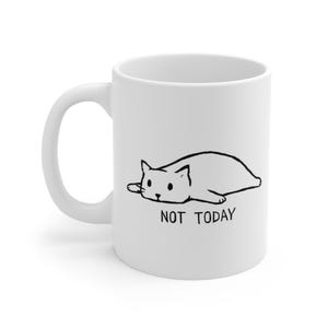 Könnte beinhalten: Weißer Keramikbecher mit einer Schwarz-Weiß-Illustration einer liegenden Katze. Der Text "NOT TODAY" ist unter der Katze aufgedruckt. Der Becher hat einen gebogenen Henkel.