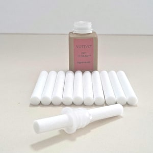 May include: A set of white diffuser sticks and a small brown bottle with a white label that reads "Votivo Red Currant" fragrance oil.