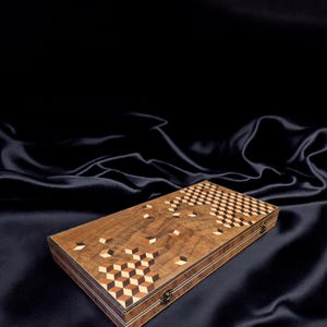 May include: A wooden game board with a geometric pattern of cubes in shades of brown, black, and white. The board has a dark brown wood frame and a brass latch.