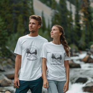 Ein männliches und weibliches Modell steht vor einem Bach im Wald. Sie Tragen ein weisses T-Shirt mit Naturmotiv darauf. Auf dem Motiv ist der Wald, ein Bach, die Sonne und kleine Hügel abgebildet. Das Motiv ist schwarz und Minimalistisch.