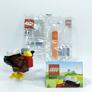 May include: LEGO 40011 Thanksgiving Turkey building set. The set includes a brown, orange, yellow, and white turkey with a white head and a yellow beak. The set also includes a small instruction booklet with a picture of the turkey on the front.