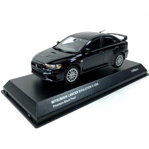 Könnte beinhalten: Schwarzes Modellauto eines Mitsubishi Lancer Evolution X GSR auf einem schwarzen Sockel. Das Modell hat silberne Räder und einen Heckspoiler. Auf dem Sockel steht "MITSUBISHI LANCER EVOLUTION X GSR Phantom Black Pearl".
