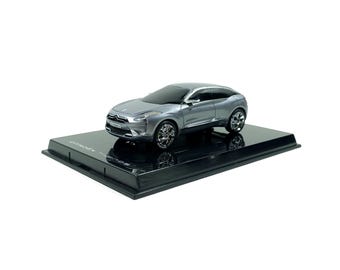 May include: A silver Citroen model car, displayed on a black base. The car has a sleek, modern design with detailed wheels and a glossy finish. The base has the text "CITROEN HYPNOS".