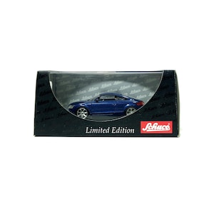 Può includere: Un'auto modello blu in una scatola nera. L'auto è una coupé con ruote argentate. La scatola presenta le parole "Limited Edition" e il marchio "Schuco" in rosso e bianco.